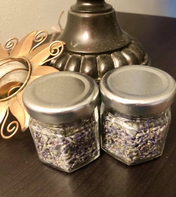 two hexagon shaped jars of dried lavender on a brown table