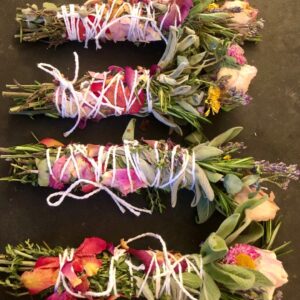 mixed dried flowers and herbs tied into a stick on a black background