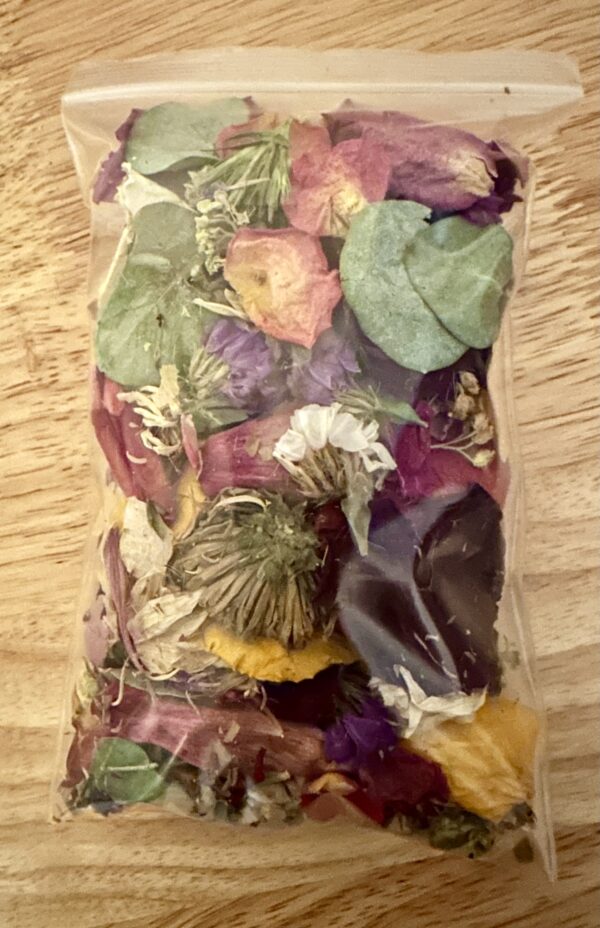 a close up of a dried confetti flower pouch against a wood background