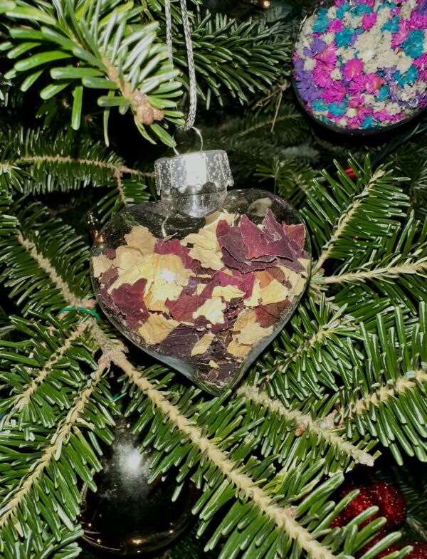 dried flower heart ornament filled with red and white rose petals and hanging from a Christmas tree