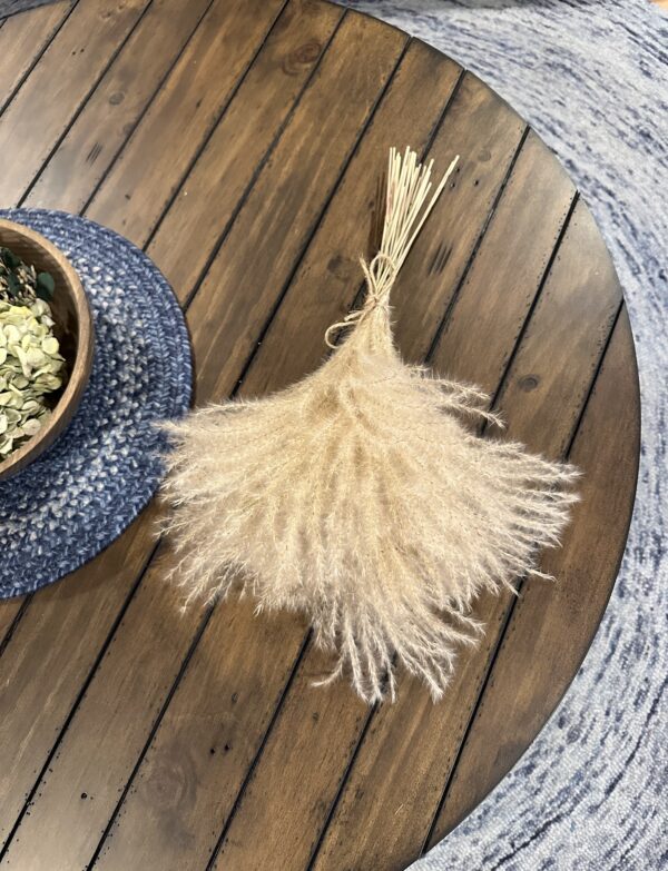 dried pampas grass stem tied in a bouquet on a rustic brown table