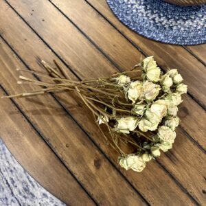 mini white dried roses on a rustic wood table