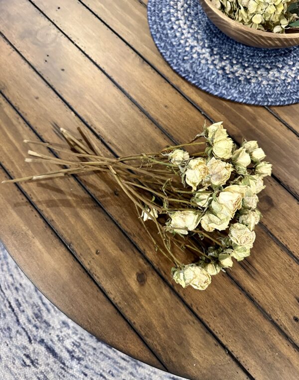 mini white dried roses on a rustic wood table