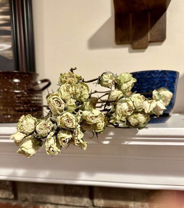 mini white dried roses on a fireplace mantle